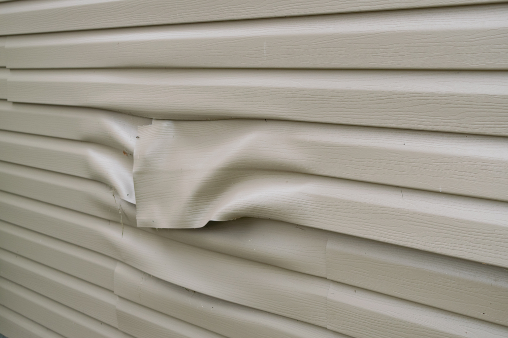 Warped Tan Vinyl Siding on House