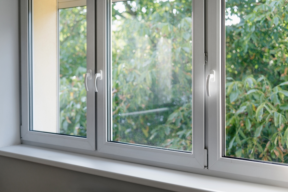 White window frame with modern aluminium profiles in bedroom. Natural light at living room.