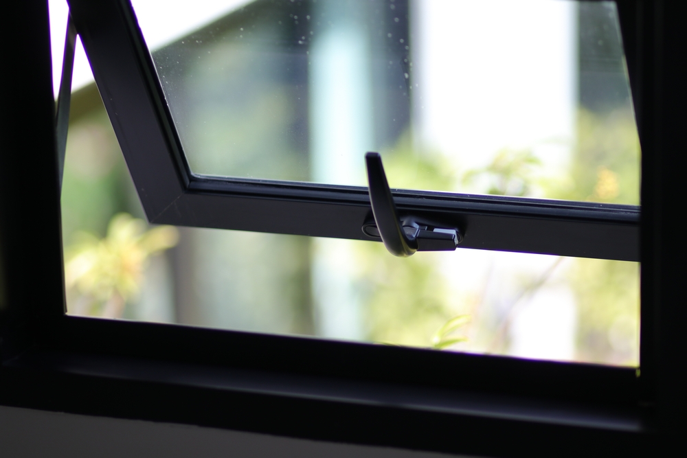 Awning window frame open, black metal detail with nature view and free space.